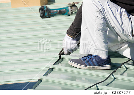 屋根工事　ガルバリウム鋼板を加工している屋根職人 32837277