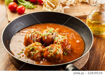 Meatballs with tomato sauce on black pan Meatballs with tomato sauce on black pan 32839529