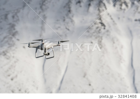 Closeup drone are flying over the snow mountain background Closeup drone are flying over the snow mountain background 32841408