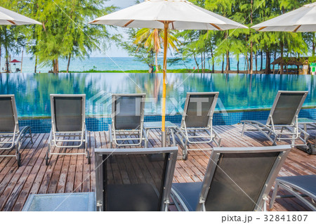 Swimming pool with relaxing seats near the sea . Swimming pool with relaxing seats near the sea . 32841807