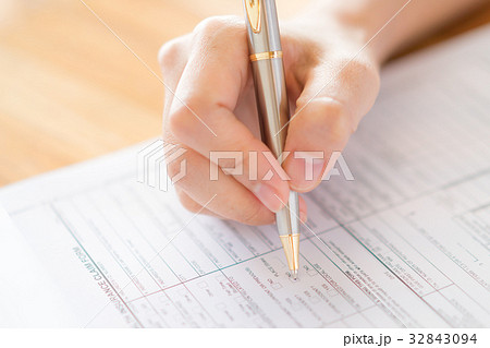 Hand with pen over application form Hand with pen over application form 32843094