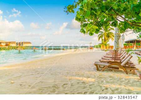 Beach chairs with umbrella at Maldives island, white sandy beach and sea . Beach chairs with umbrella at Maldives island, white sandy beach and sea . 32843547