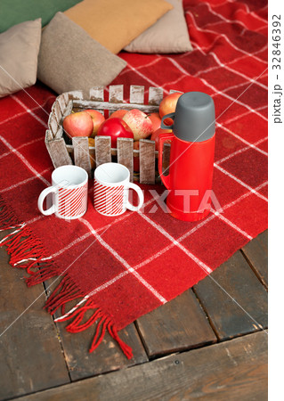 Autumn picnic on the terrace. Red plaid, basket Autumn picnic on the terrace. Red plaid, basket 32846392