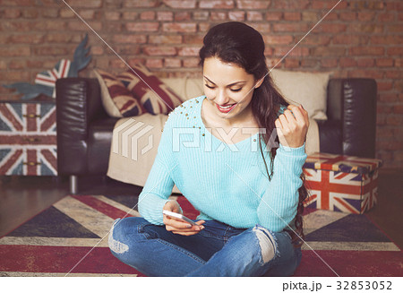 Young beautiful woman sitting with smart phone 32853052