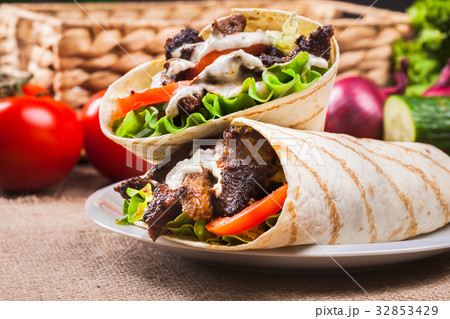 Tasty fresh wrap sandwich with beef and vegetables 32853429