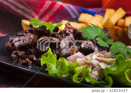 Kebab of beef with french fries and salad 32853437