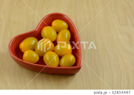Lower acid yellow cherry tomatoes in red heart Lower acid yellow cherry tomatoes in red heart 32854497