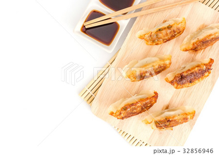 Gyoza dumplings on wooden plate on a white Gyoza dumplings on wooden plate on a white 32856946