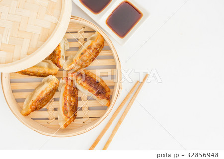 Gyoza dumplings in bamboo basket on a white Gyoza dumplings in bamboo basket on a white 32856948