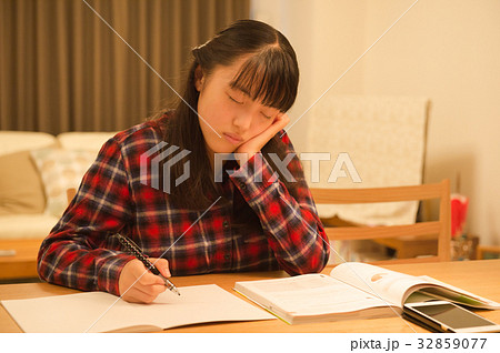 居眠りする勉強中の女の子の写真素材