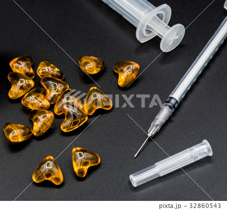 hypodermic syringe and pill on black background hypodermic syringe and pill on black background 32860543