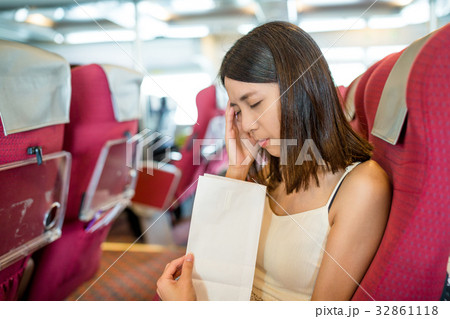 Woman feeling unwell and vomit on paper bag inside ferry Woman feeling unwell and vomit on paper bag inside ferry 32861118
