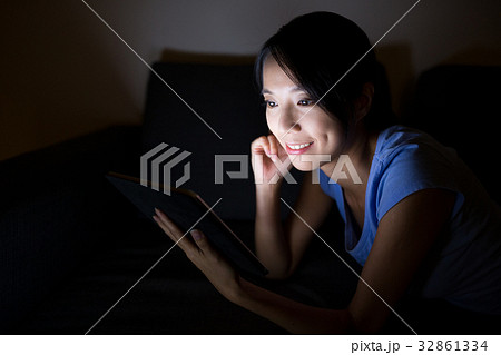 Asian woman using digital tablet and lying on bed Asian woman using digital tablet and lying on bed 32861334