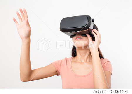 Woman looking though the VR device and hand up Woman looking though the VR device and hand up 32861576