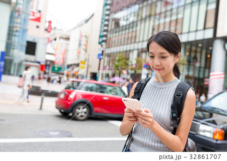 Woman using cellphone in Fukuoka city 32861707