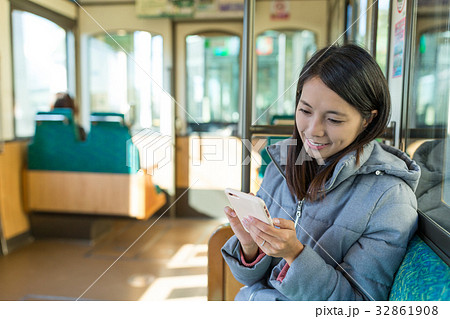 Woman sending sms on cellphone on train Woman sending sms on cellphone on train 32861908