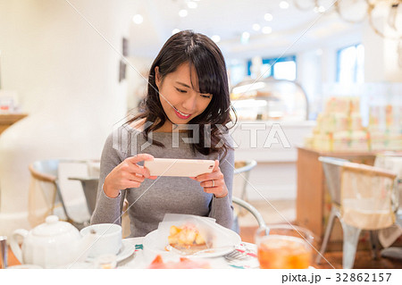 Woman taking photo on her slice of cake Woman taking photo on her slice of cake 32862157