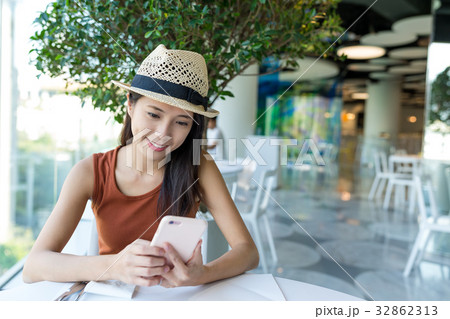 Woman using cellphone in cafe Woman using cellphone in cafe 32862313