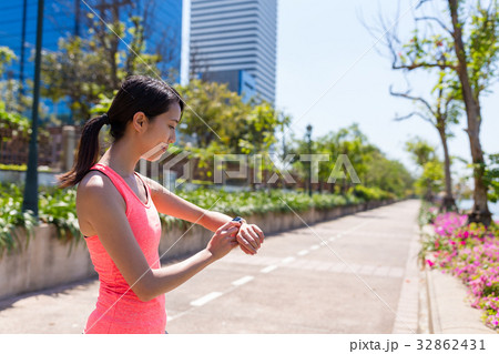 Sport Woman running with smart watch in park 32862431