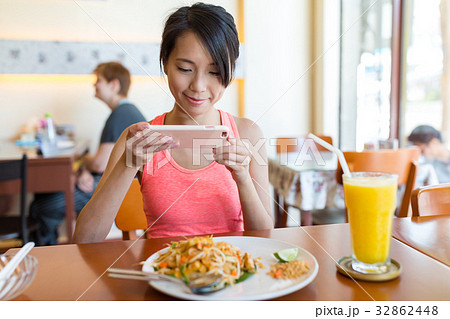 Woman taking photo on dishes before eat Woman taking photo on dishes before eat 32862448