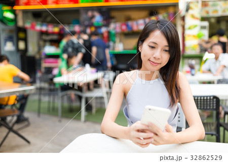 Woman using mobile phone at outdoor market Woman using mobile phone at outdoor market 32862529