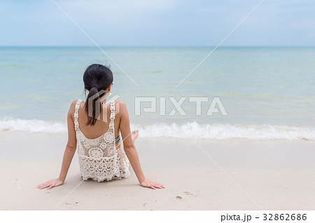 Woman sitting on the sand beach 32862686