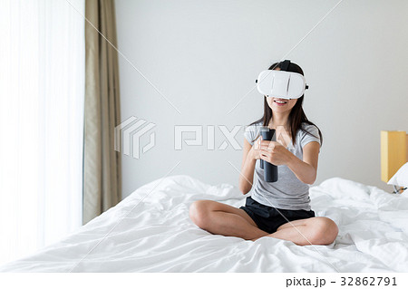 Woman play with VR device on bed 32862791