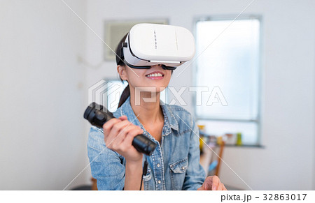 Woman play game with virtual reality device and joystick Woman play game with virtual reality device and joystick 32863017