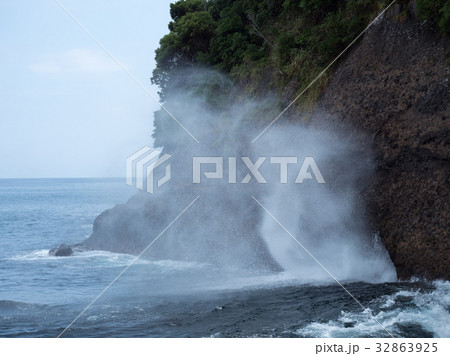 横穴洞窟から海水が噴出する汐吹岩 32863925