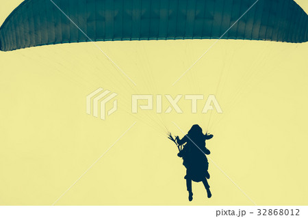 Silhouettes of skydivers in a yellow sky. Toned im Silhouettes of skydivers in a yellow sky. Toned im 32868012