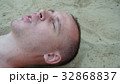 a young man lies on the sand on the beach 32868837