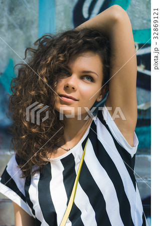 Woman with curly hair in a striped T-shirt Woman with curly hair in a striped T-shirt 32869121