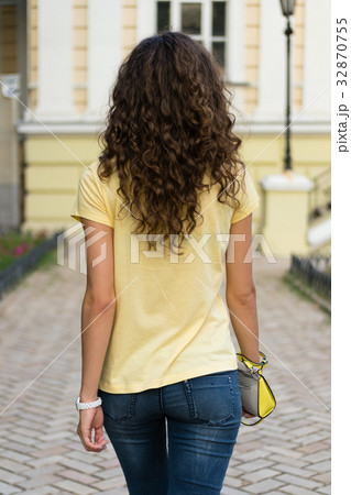 Attractive slim young woman with curly brown hair Attractive slim young woman with curly brown hair 32870755