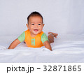 Asian infant lie on the stomach, in orange shirt 32871865