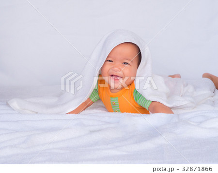 Asian infant lie on the stomach under white towel. Asian infant lie on the stomach under white towel. 32871866
