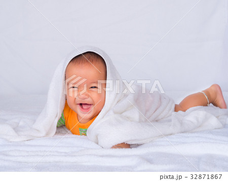 Asian infant lie on the stomach under white towel. Asian infant lie on the stomach under white towel. 32871867