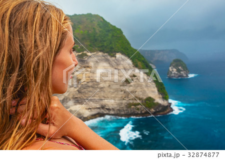 Happy woman stand at high cliff under rainy sky Happy woman stand at high cliff under rainy sky 32874877
