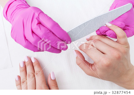 Manicurist does manicure with nail file closeup 32877454