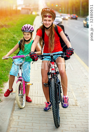 Girls children cycling on yellow bike lane. There 32880651