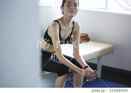 The woman is listening to music and relaxing in sport club 32886404