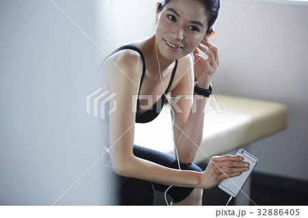 The woman is listening to music and smiling. 32886405