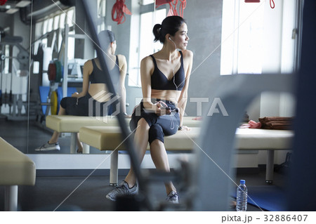 The girl is listening to music and look through the window of sport club. 32886407