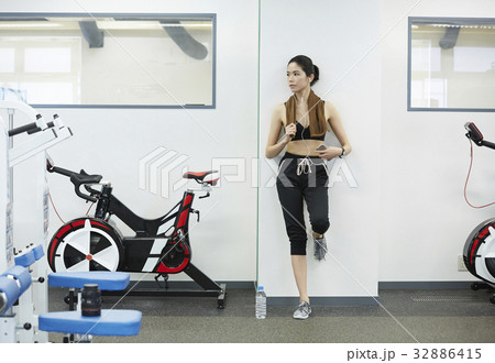 The woman is standing in the sport club. 32886415