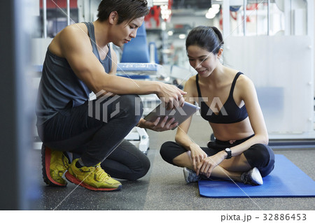 A coach is advising his trainee with a tablet 32886453