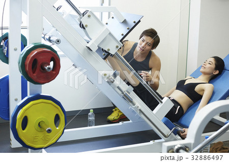 a man is instructing the girl how to practice with the machine a man is instructing the girl how to practice with the machine 32886497