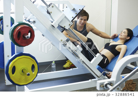 young woman is practising leg exercise with her trainer 32886541
