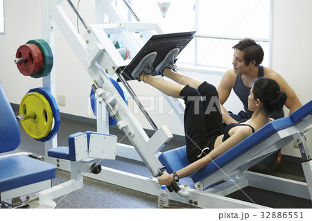 fitness trainer is helping young girl on practising exercise 32886551