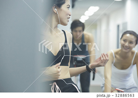 young people are talking together while training on exercise machine 32886563