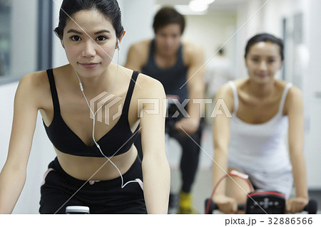 A group of three people is riding bicycle in the fitness club A group of three people is riding bicycle in the fitness club 32886566