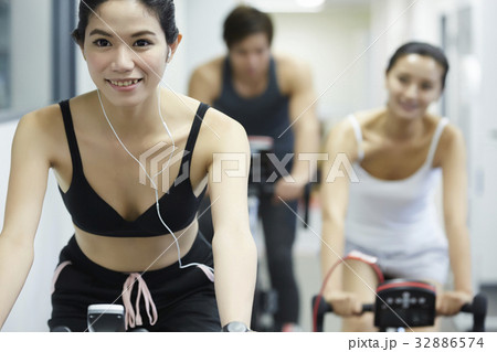 A woman practises riding bike with her teammates 32886574